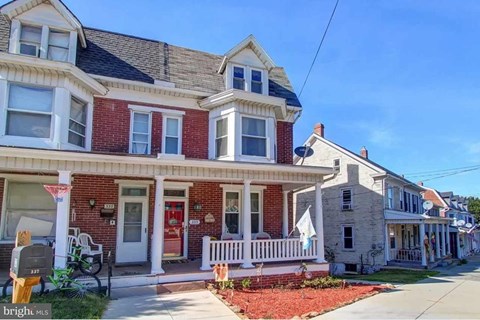 A red brick house with a white porch.