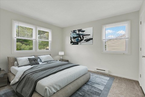 A bedroom with a large bed and a painting on the wall.
