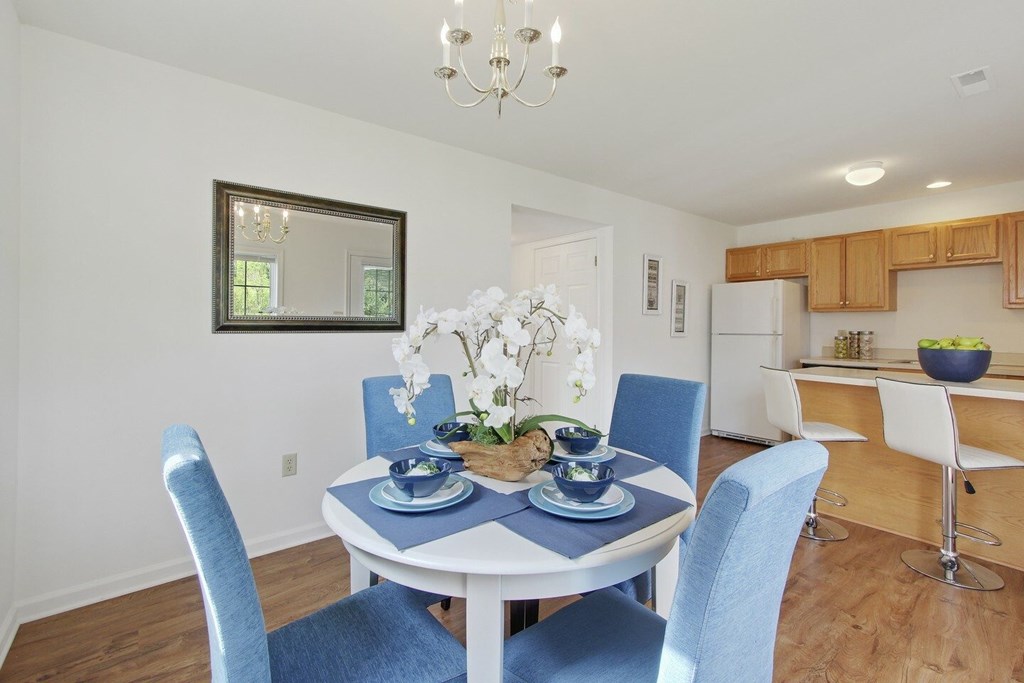 A dining room with a white table and blue chairs.