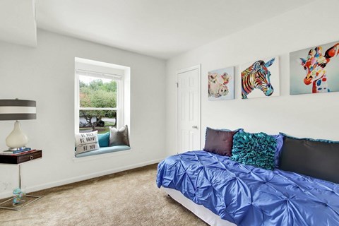 A bedroom with a blue comforter on the bed.