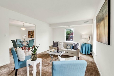 A living room with a white couch and blue chairs.