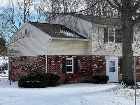 A house with a white door and a brick wall.