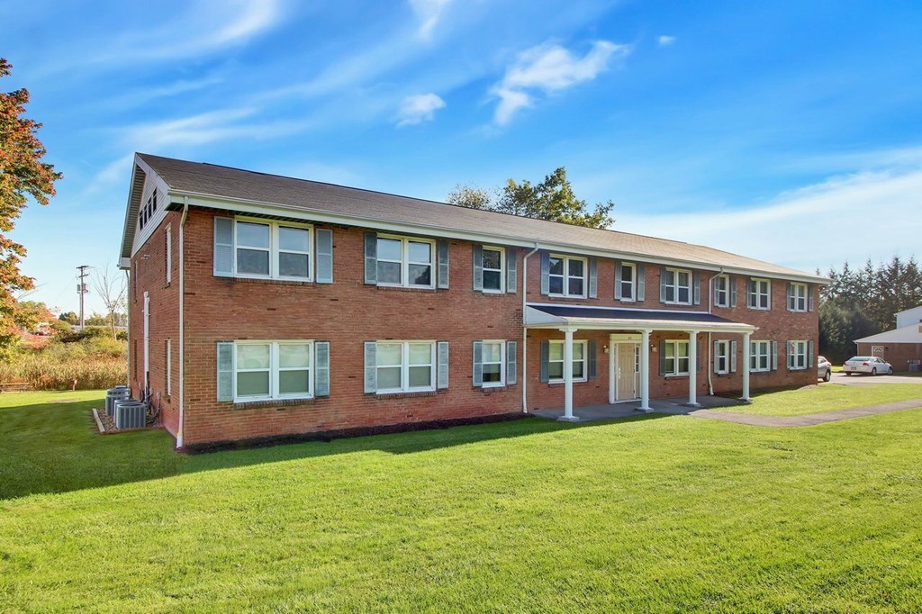 A red brick building with a white door and windows.