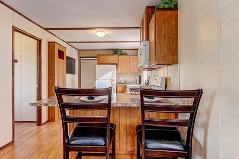 Two chairs are placed in front of a table in a kitchen.