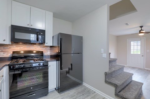 A kitchen with a black refrigerator and stove.