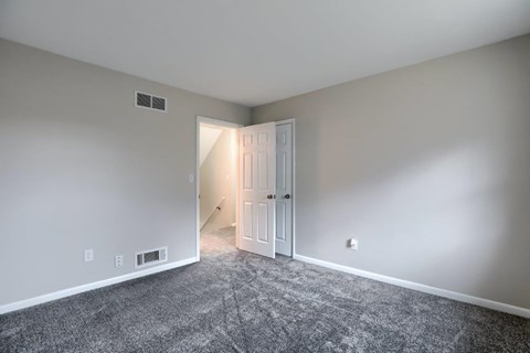 A room with a carpeted floor and a white door.