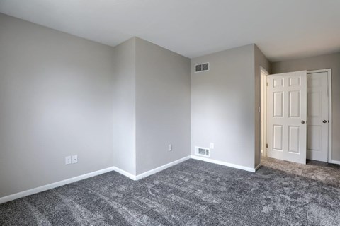 A room with a carpeted floor and a door.