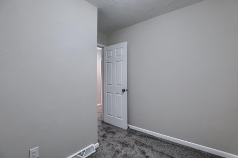 A white door is in a room with white walls.