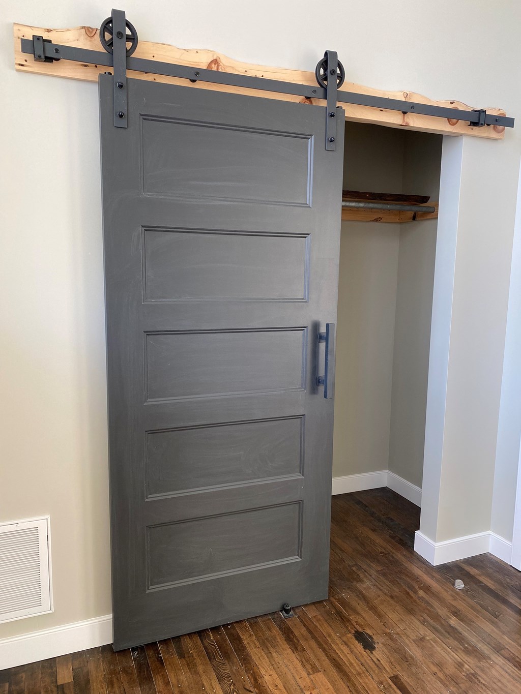 A grey door is open to a small room.