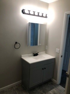 A bathroom with a sink and a mirror.