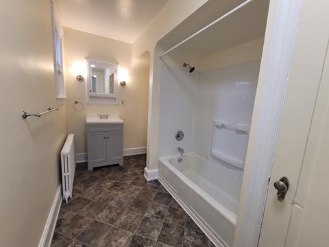 A bathroom with a white tub and a sink.