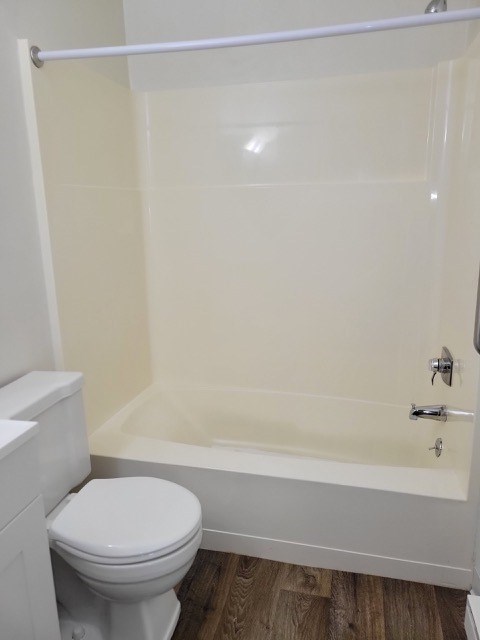 A white toilet sits next to a bathtub in a bathroom.