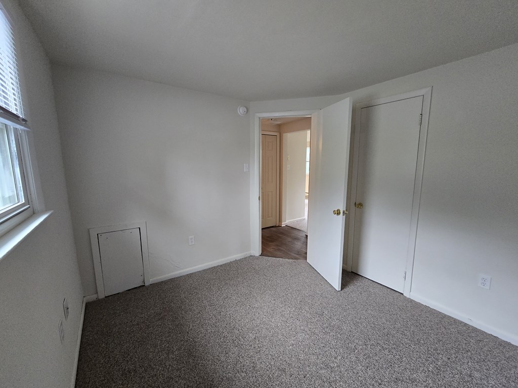 A room with white walls and carpeted floor.