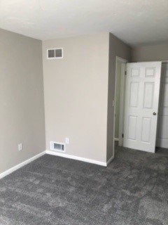 A room with a white door and a window on the wall.