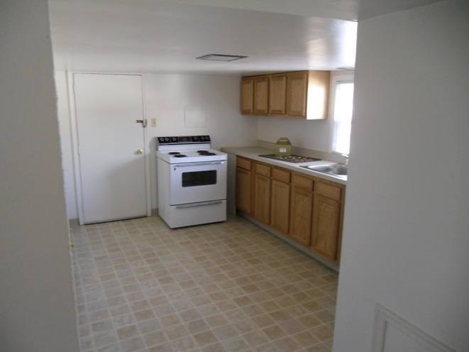 A kitchen with a white oven and wooden cabinets.