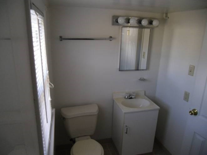 A white toilet and sink in a small bathroom.