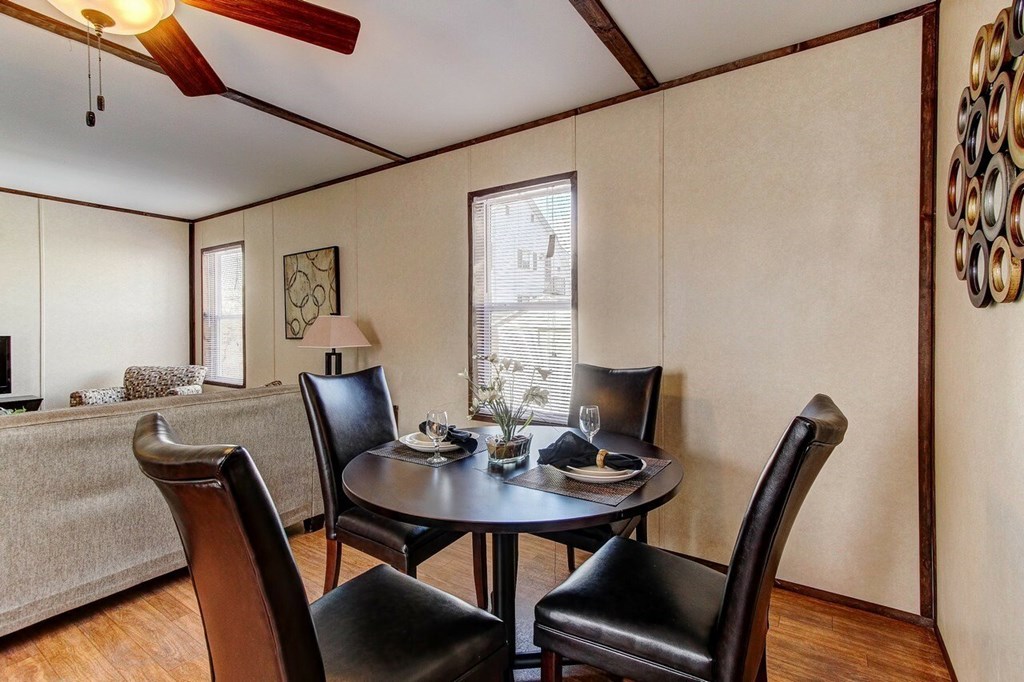 A dining room with a table and chairs.