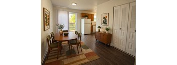 A dining room with a table and chairs.