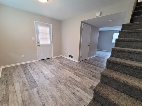 A room with a staircase leading to another room.