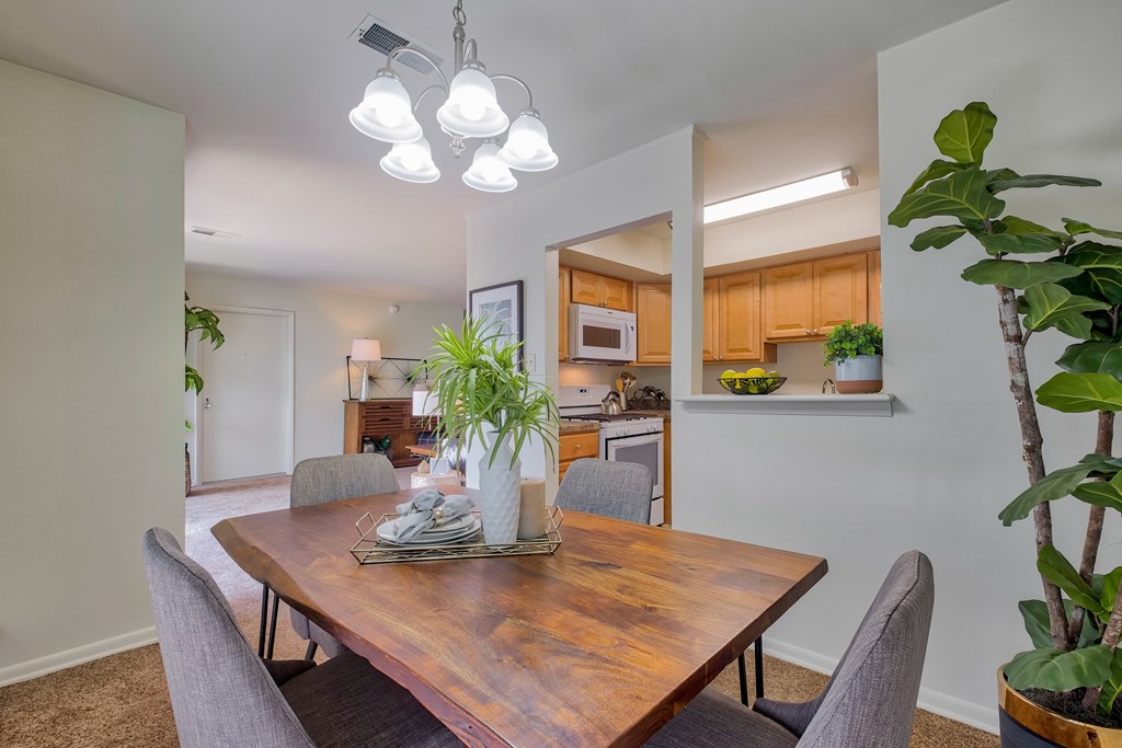 A dining room with a wooden table and grey chairs.