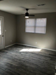 A room with a ceiling fan and a window with blinds.