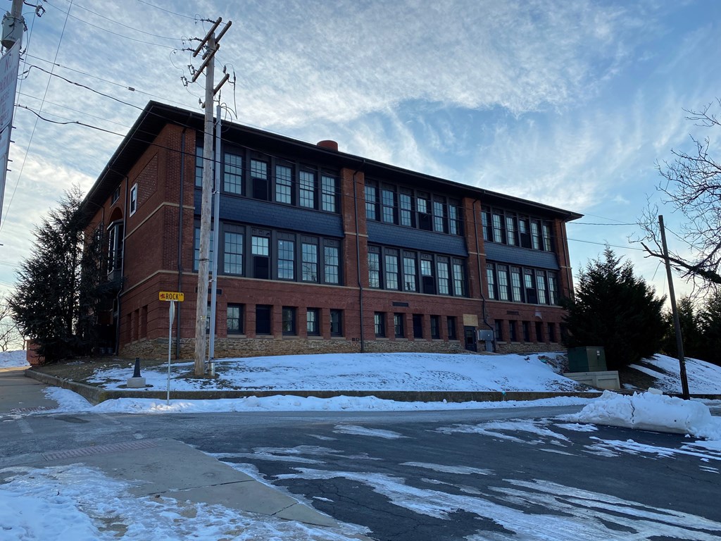 A red brick building with a yellow sign on the side.