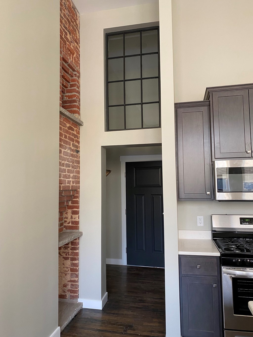 A kitchen with a brick wall and a stove top oven.