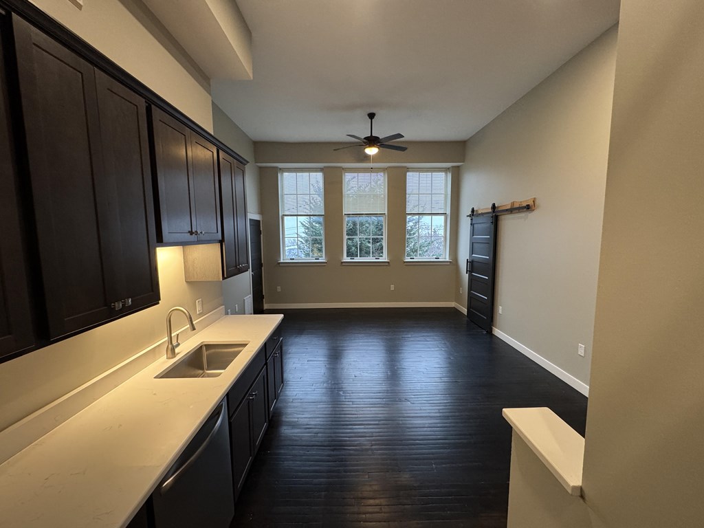 A kitchen with dark wood cabinets and a white countertop.