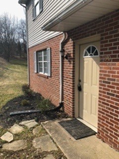 A brick house with a white door and a window.