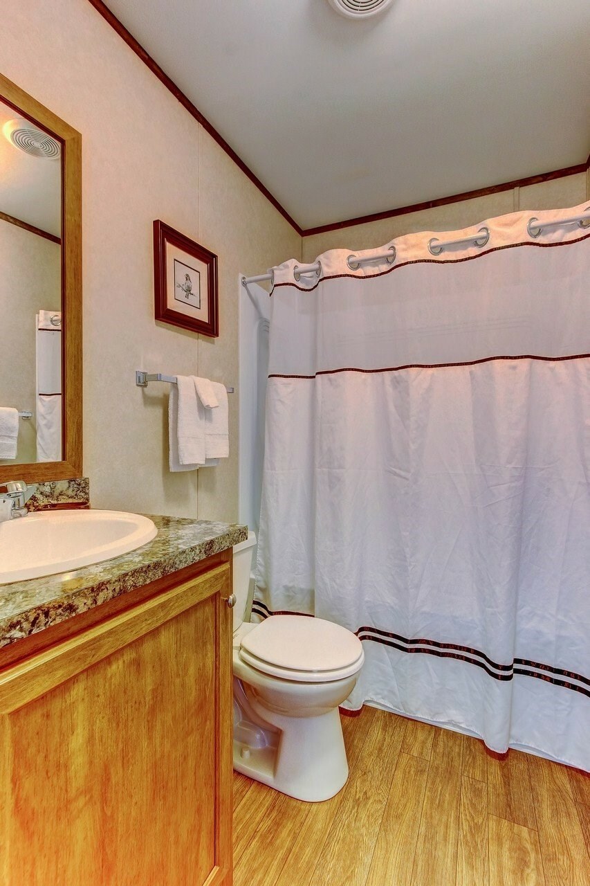 A white toilet sits next to a sink in a bathroom.