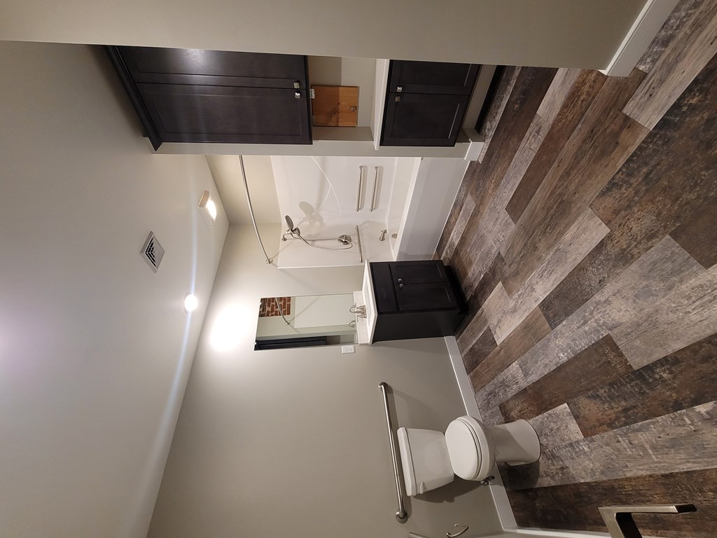 A bathroom with a wooden wall and a toilet.