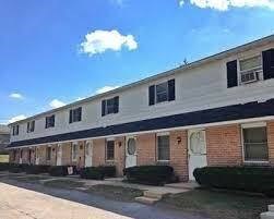 A long white building with a black stripe and windows.