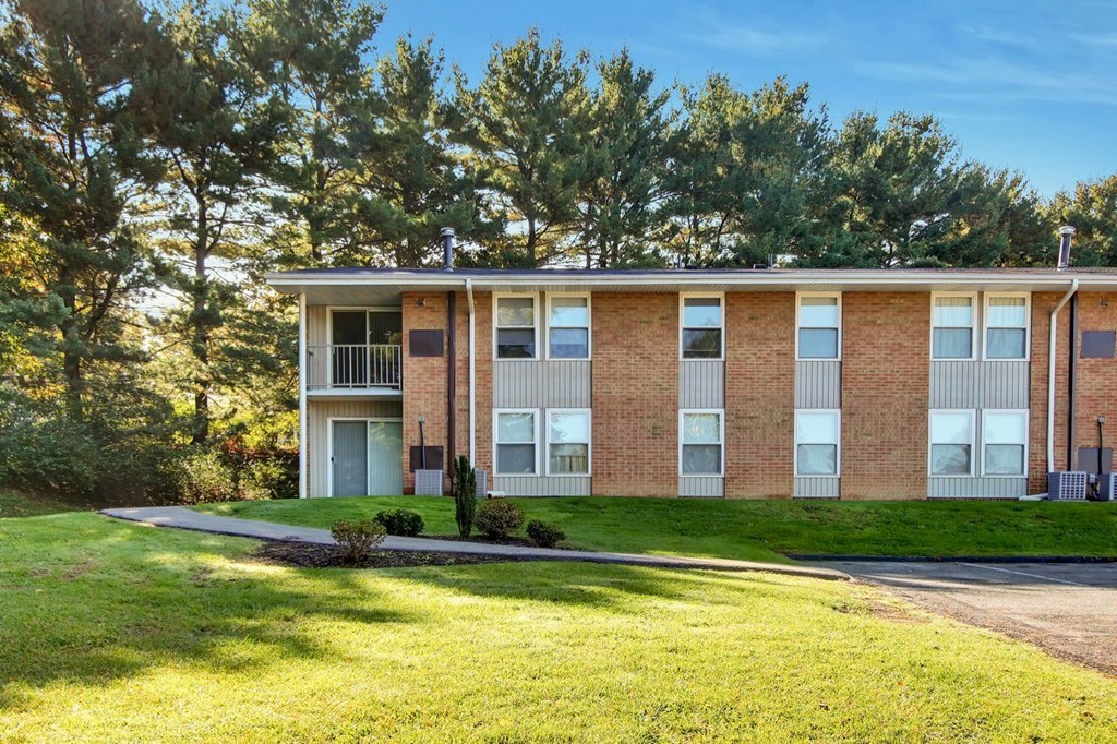 A brick apartment building with a green lawn in front.