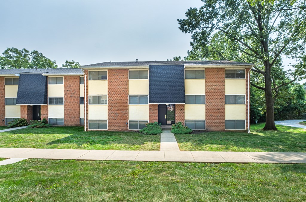 A row of red brick apartment buildings with white windows and doors.