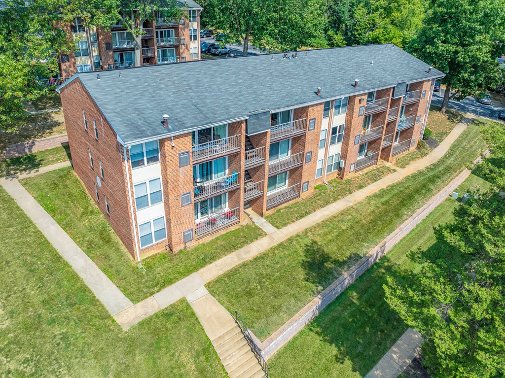 A red brick building with a green lawn in front.