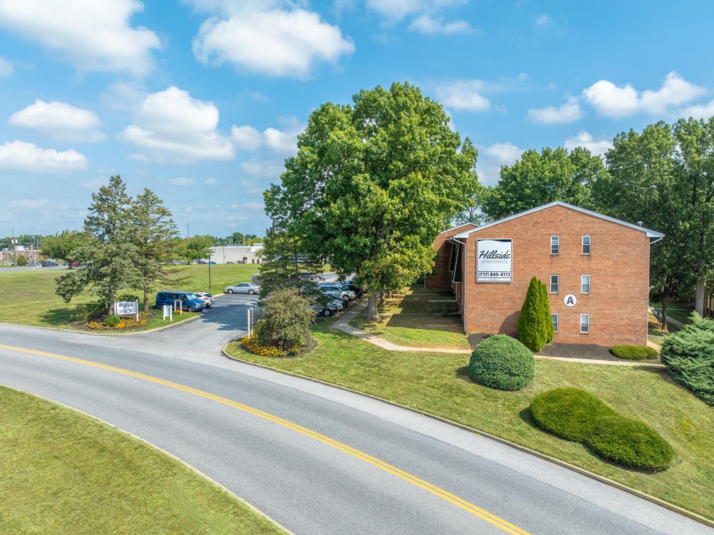 A road with a yellow line in the middle and a building on the right.