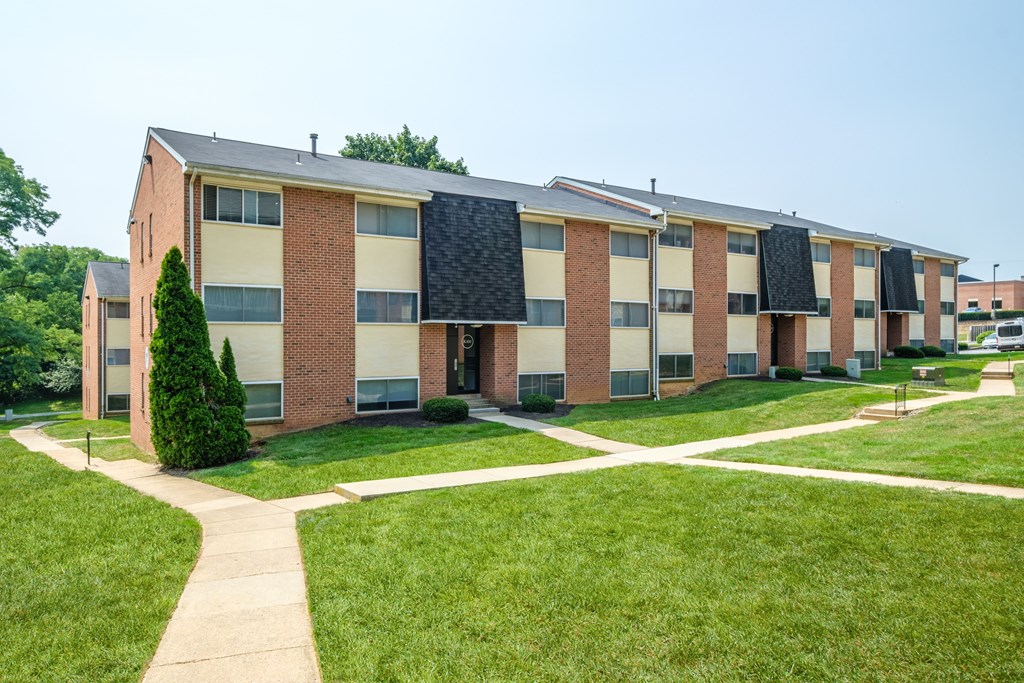 A long building with a lot of windows and a green lawn in front.