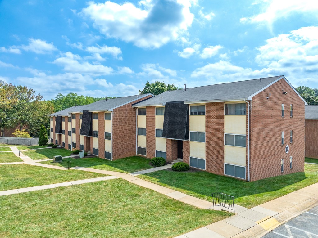 A series of red brick apartment buildings with black awnings.