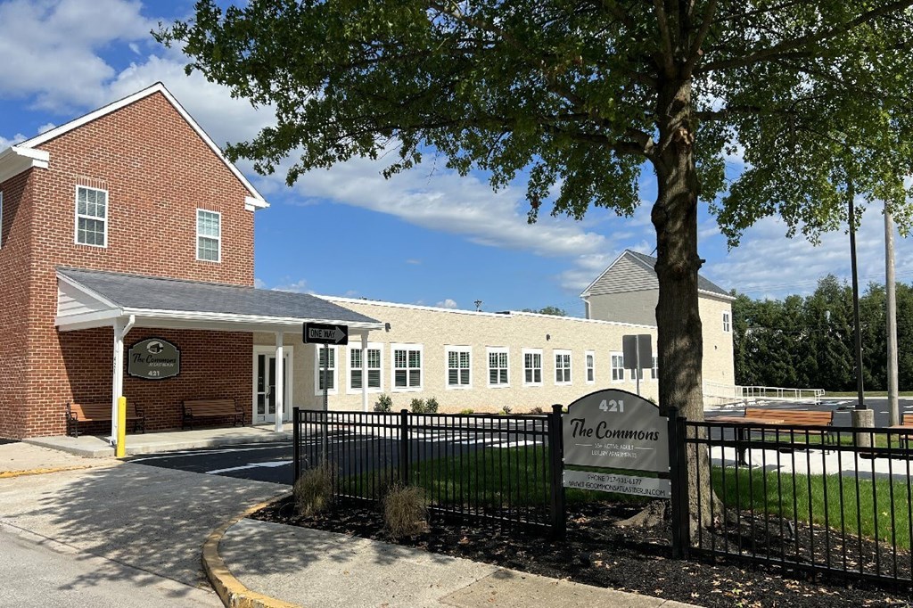The Commons is a brick building with a black fence in front.