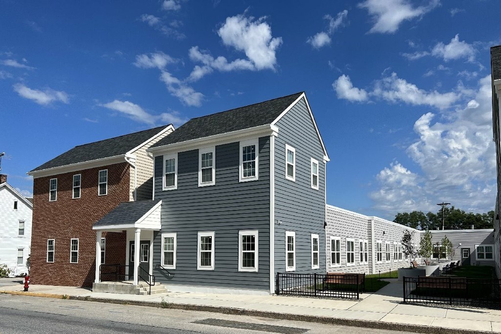 A grey house with a black fence in front.