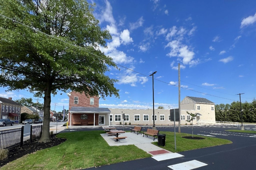 A sunny day at a park with a building in the background.