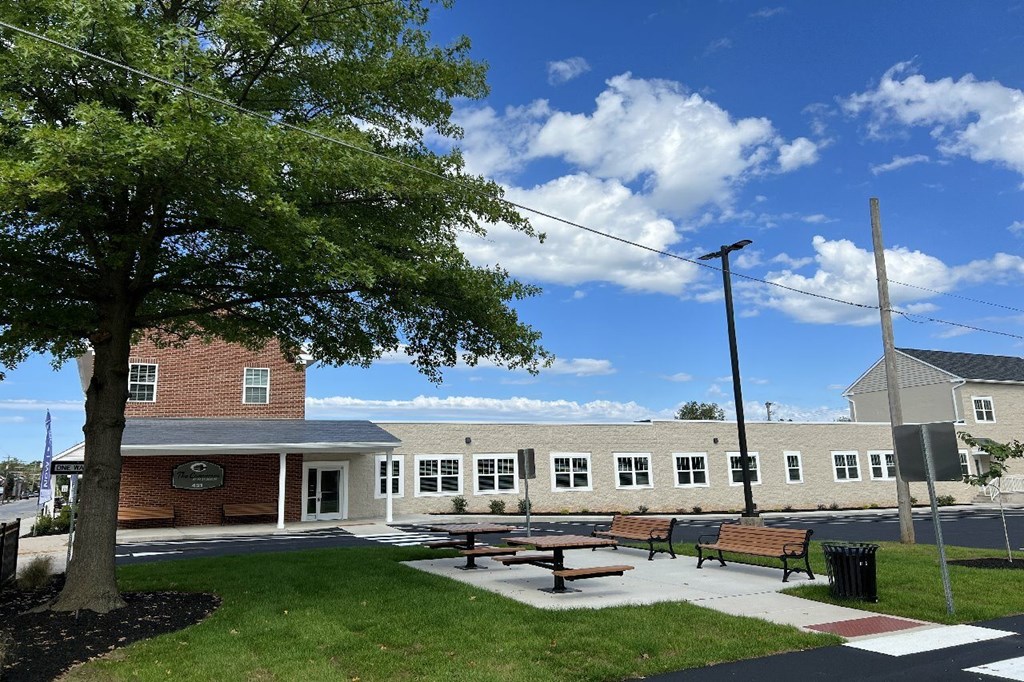 A school building with a tree in front of it.