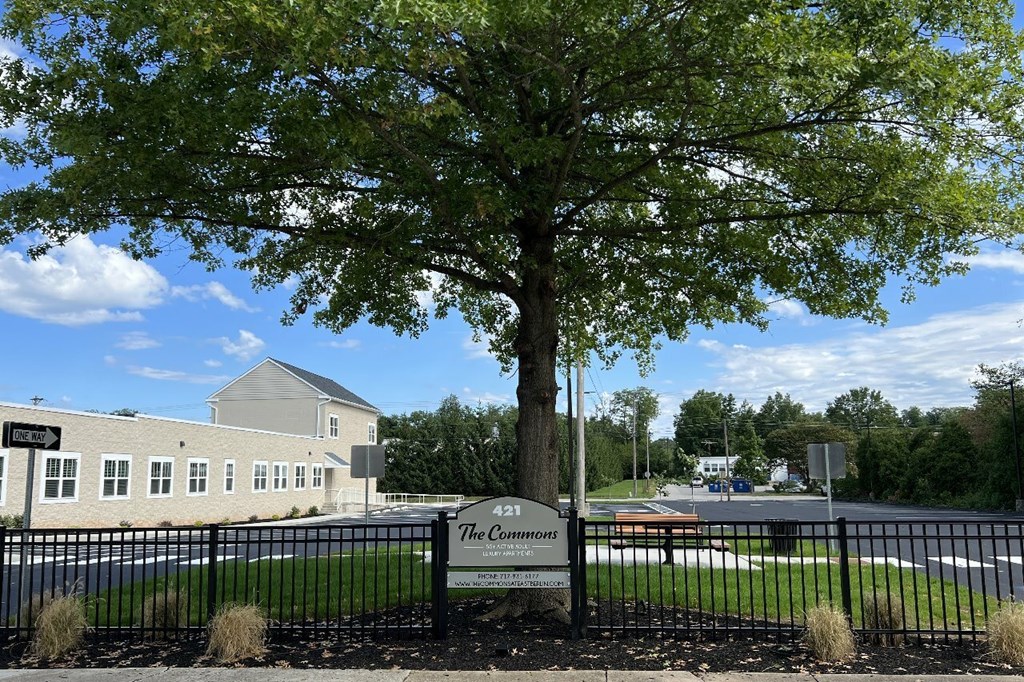 A sign that says The Cornlands in front of a building.