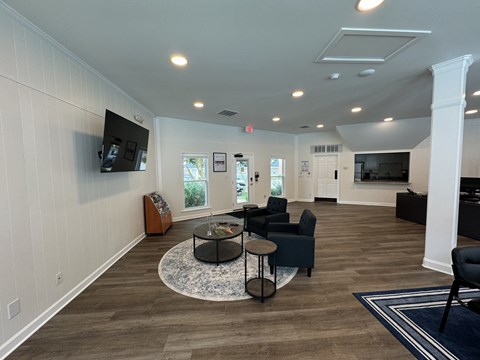 A living room with a black coffee table and a flat screen TV mounted on the wall.