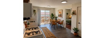 A kitchen with a stove, sink, and dining table.