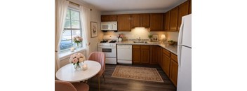 A kitchen with a table and chairs by a window.