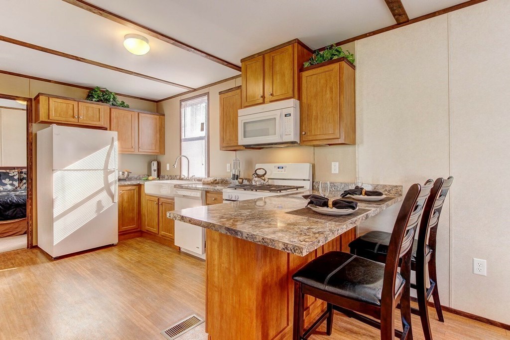 A kitchen with wooden cabinets and a granite countertop.