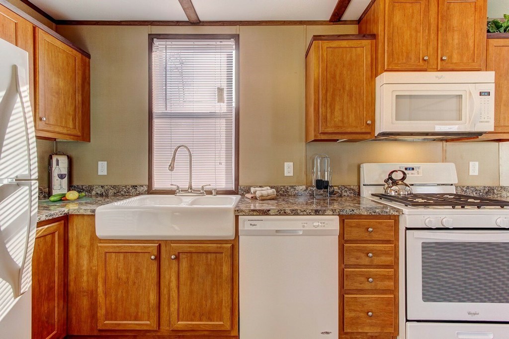 A kitchen with wooden cabinets and white appliances.