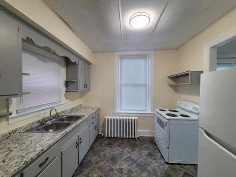 A kitchen with a white stove and a window.