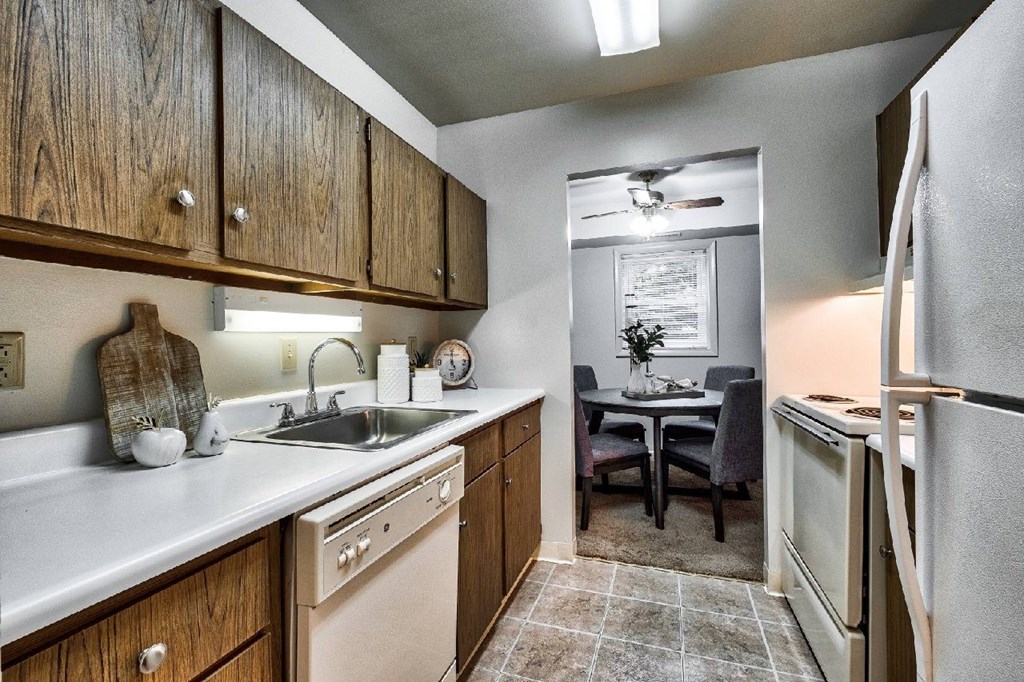 A kitchen with wooden cabinets and a white fridge.
